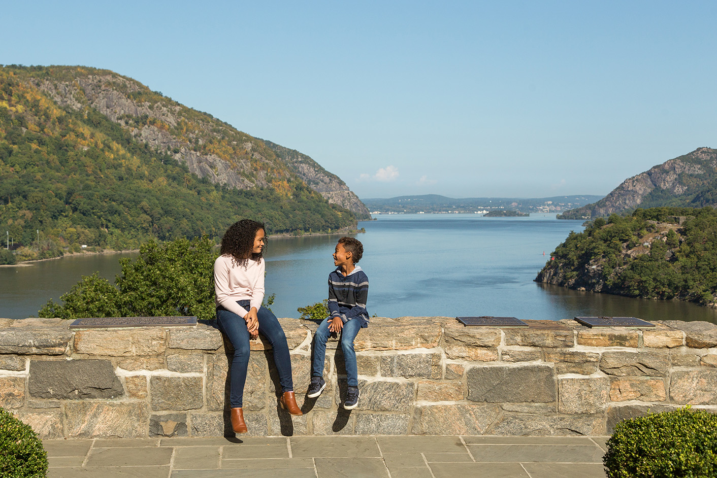 Two children sitting on a bridge overlooking the Hudson at the West Point Museum