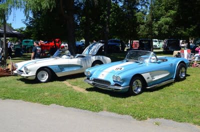 Two convertible first-generation Chevrolet Corvettes (1953-1962), one white, one sky blue, parked on the grass at the Dutchess County Fairgrounds, Rhinebeck.