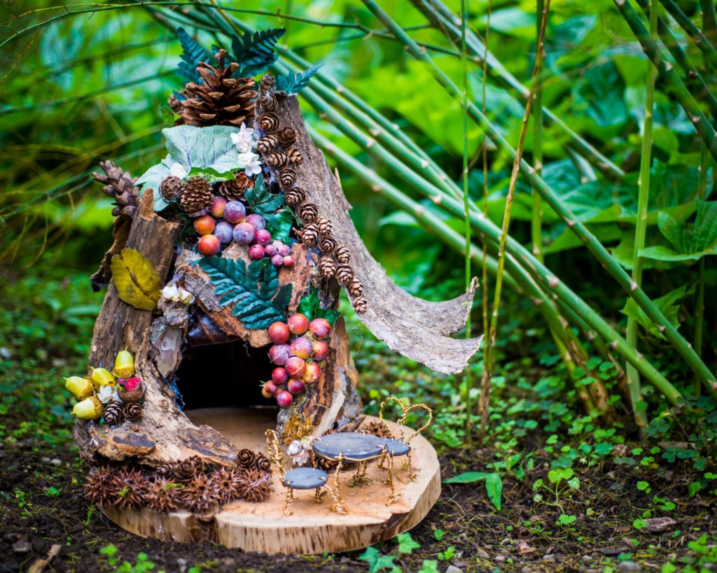 Tiny wooden fairy fouse decorated with pine cones, tree bark, leaves and tiny furniture hidden in the woods at Locust Grove Estate, Poughkeepsie