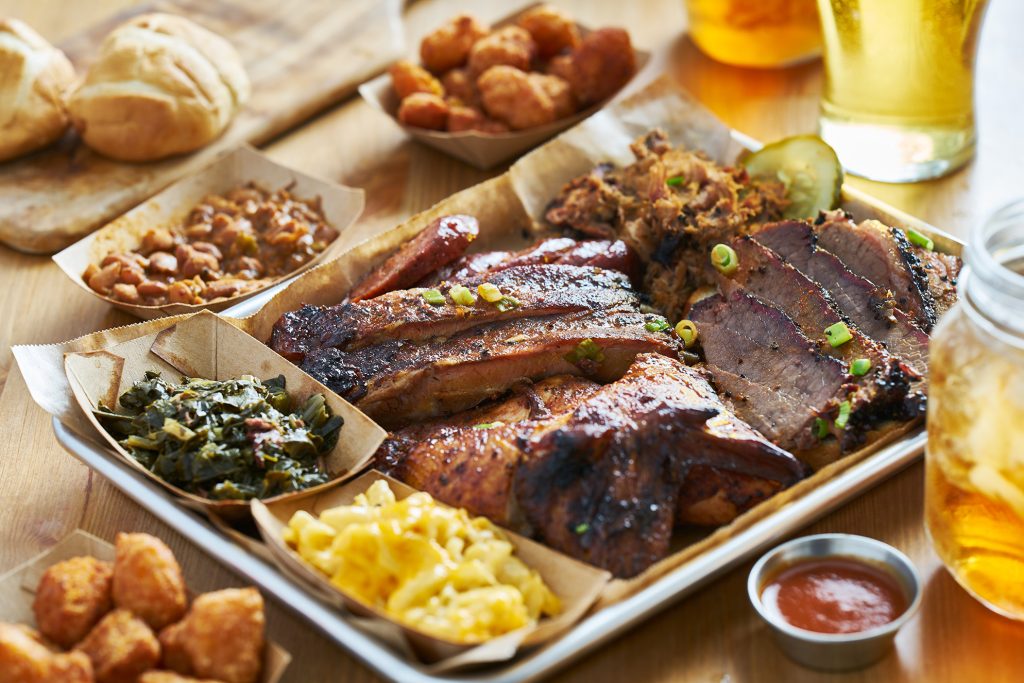 Texas style bbq tray with smoked brisket, st louis ribs, pulled pork, chicken, hot links, and sides