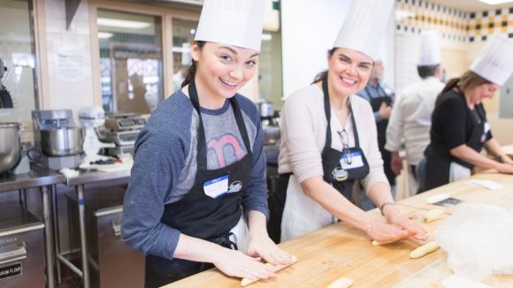 Two baking students roll dough in a kitchen at the Culinary Institute of America in Hyde Park.