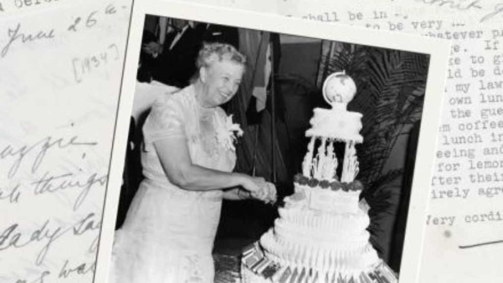 A black and white photo of an aging Eleanor Roosevelt, who smiles as she slices her birthday cake.