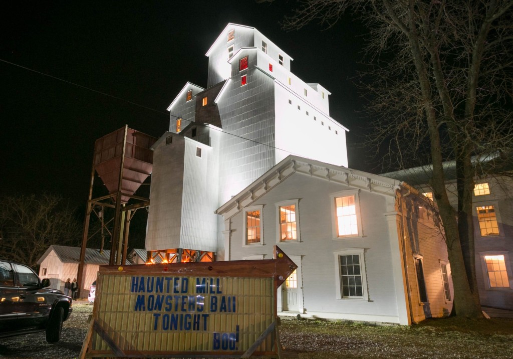 The Maxon Mills art gallery in Wassaic, a seven story, white grain elevator illuminated against a black night sky.