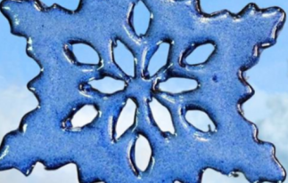 A closeup view of a blue ceramic snowflake.