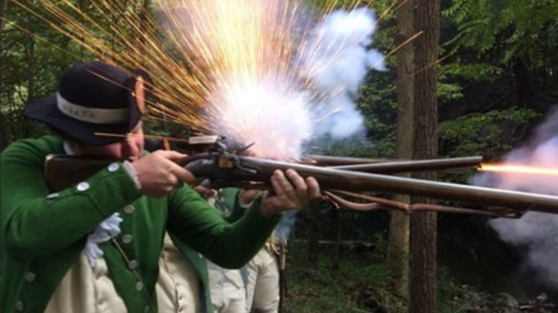 A Revolutionary War era soldier fires a musket at Mount Gulian Historic Site in Beacon