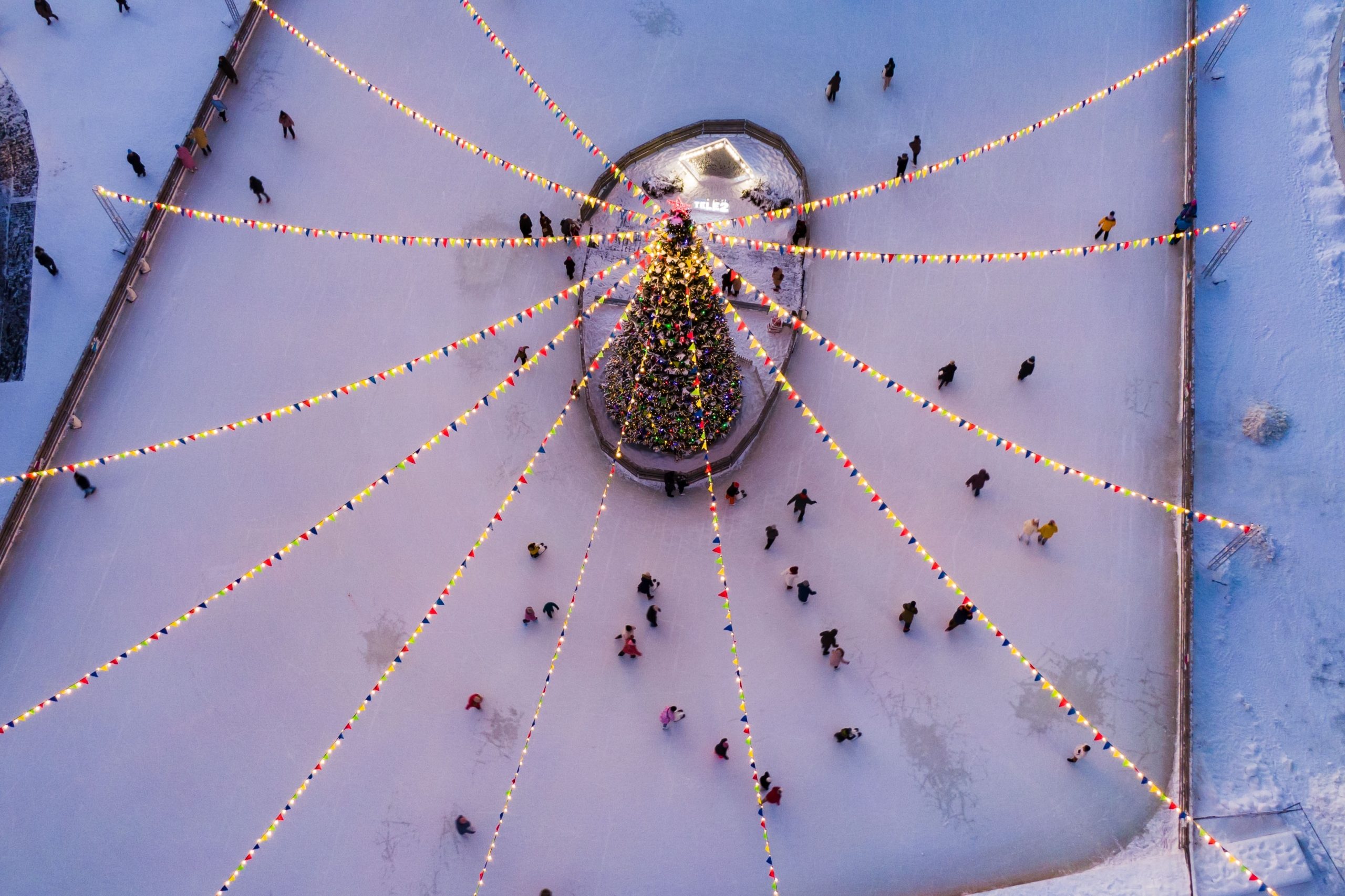 A view of an ice skating rink and holiday tree from above.