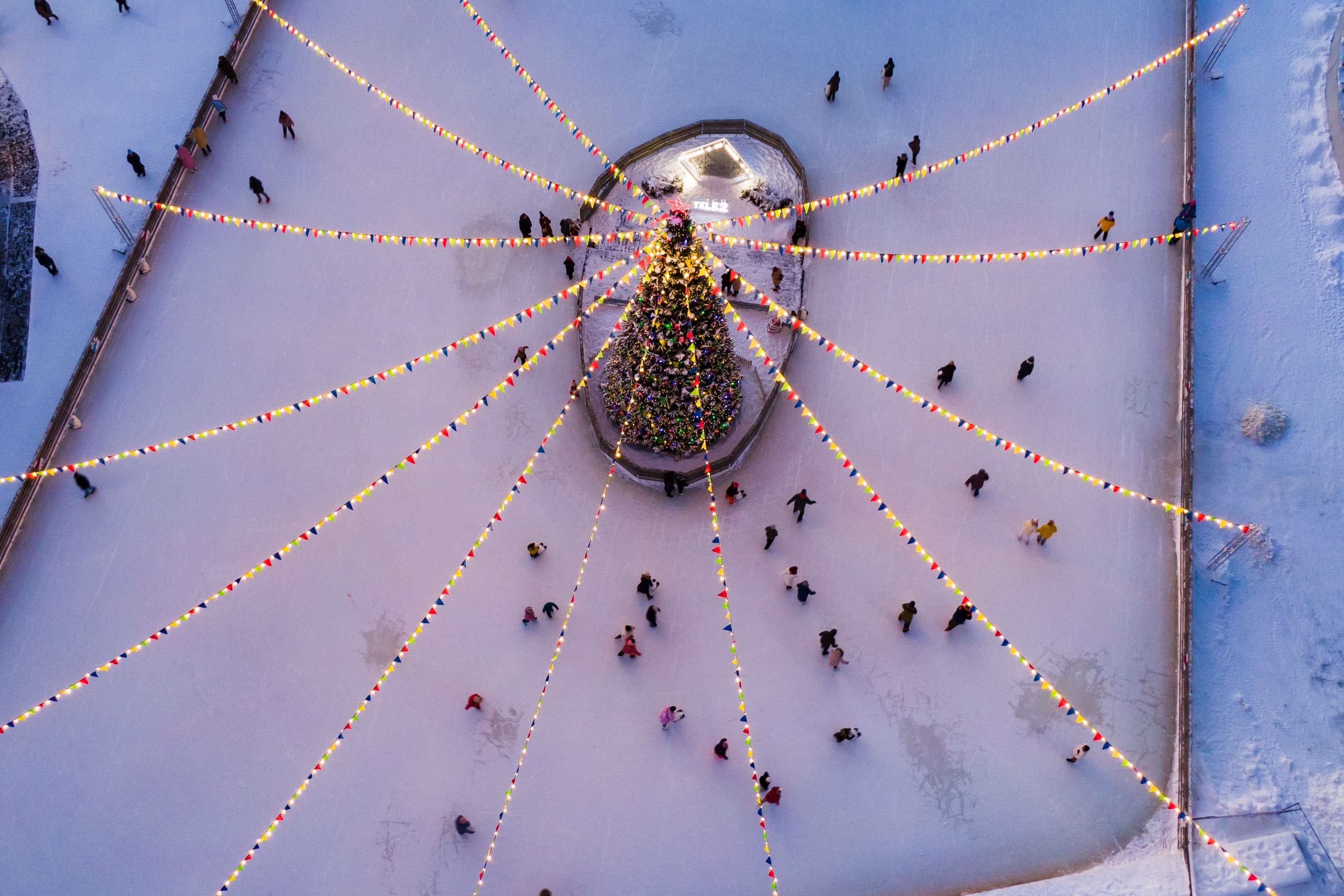 A view of an ice skating rink and holiday tree from above.