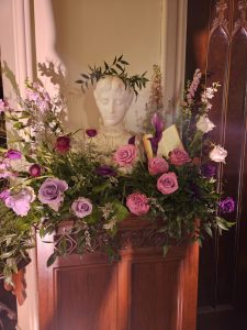 A statue at Lyndhurst adorned with pink flowers.