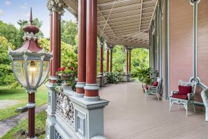 The whimsically decorated porch of the Octagon House painted in reds and pinks.