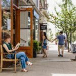 A woman sits outside the shops on Tarrytown's Main Street.