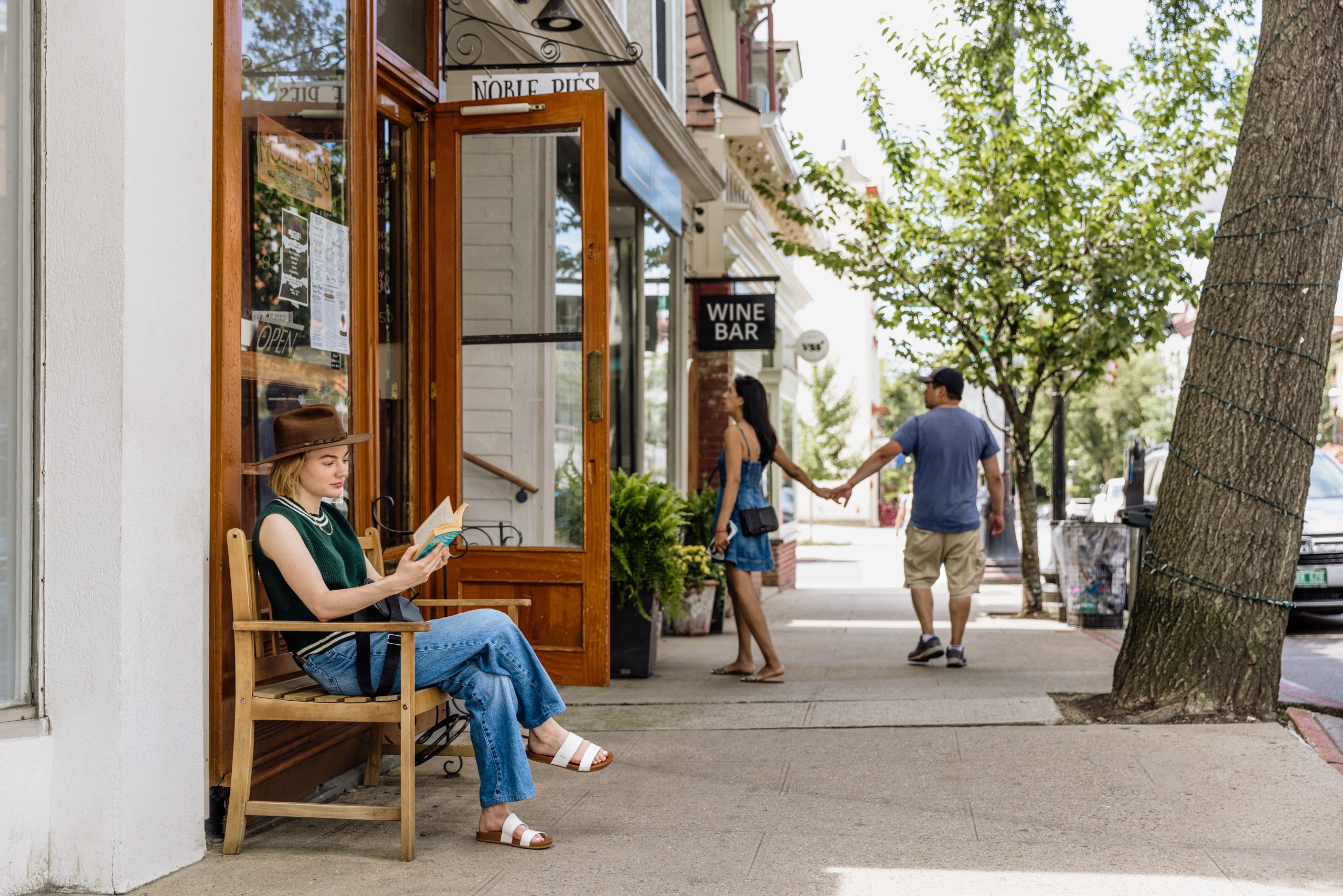 A woman sits outside the shops on Tarrytown's Main Street.