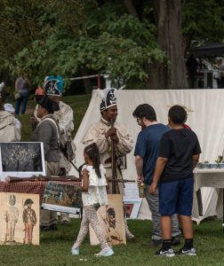 People visit an encampment with reenactors at REV FEST.