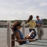 three adults stand around a platform overlooking a blue river at Quiet Cove Riverfront Park in Poughkeepsie