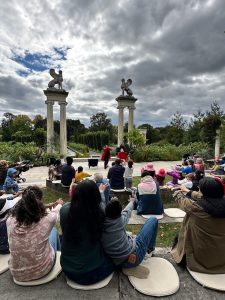 A crowd of people sits in an amphitheater watching a performance.