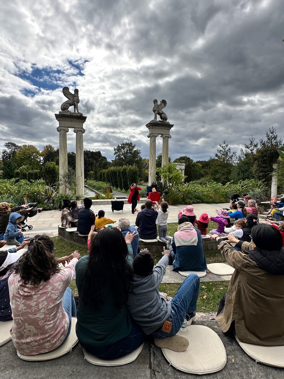 A crowd of people sits in an amphitheater watching a performance.