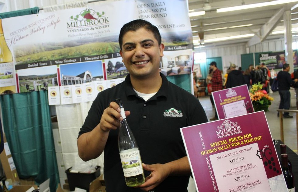 A representative of Millbrook Vineyards and Winery with a bottle of wine at the Hudson Valley Wine & Food Festival at the Dutchess County Fairgrounds in Rhinebeck