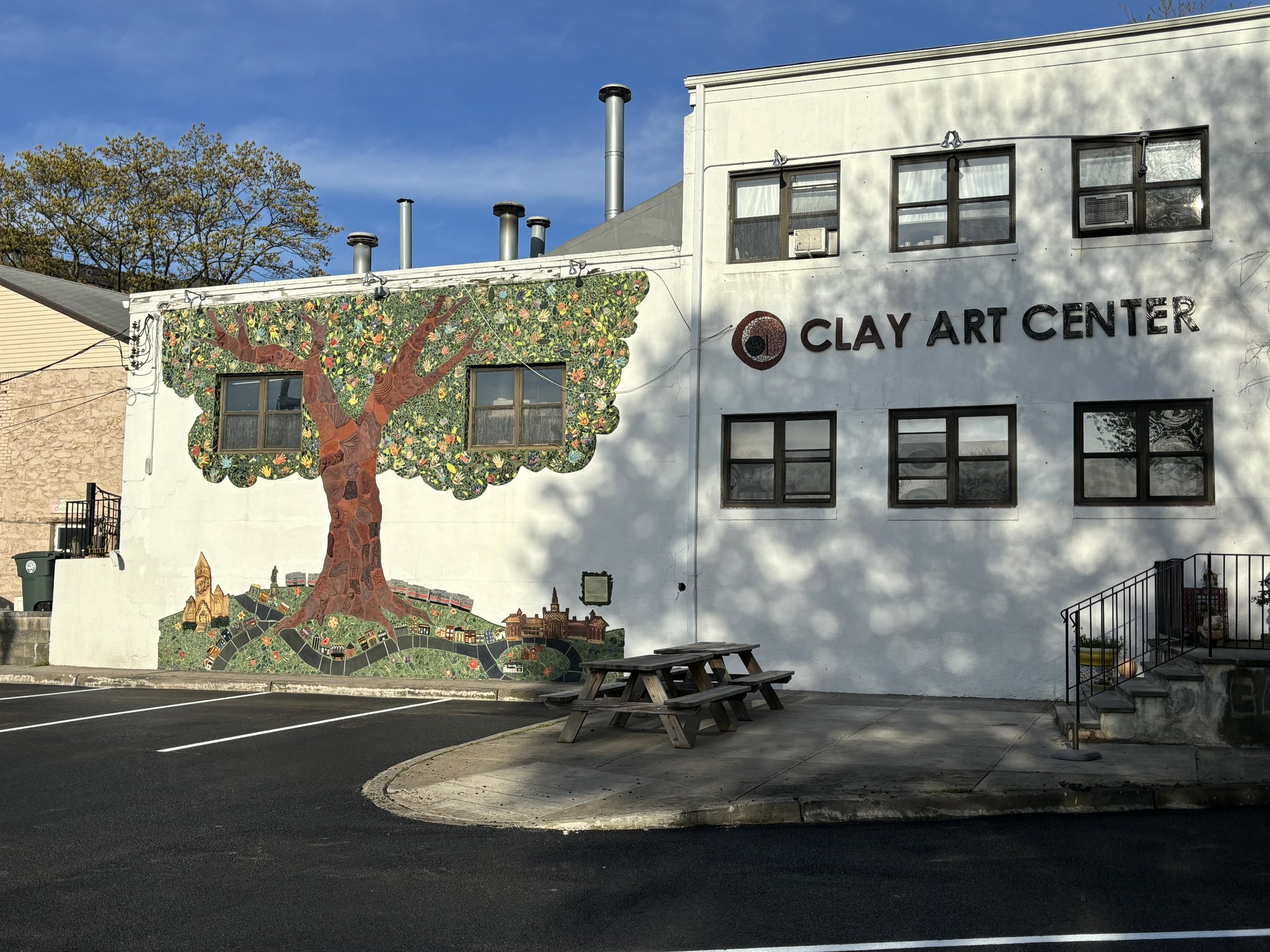 The exterior of the Clay Art Center building with a tree mural.