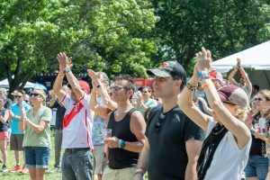 A crowd gathers in a park to listen to music.