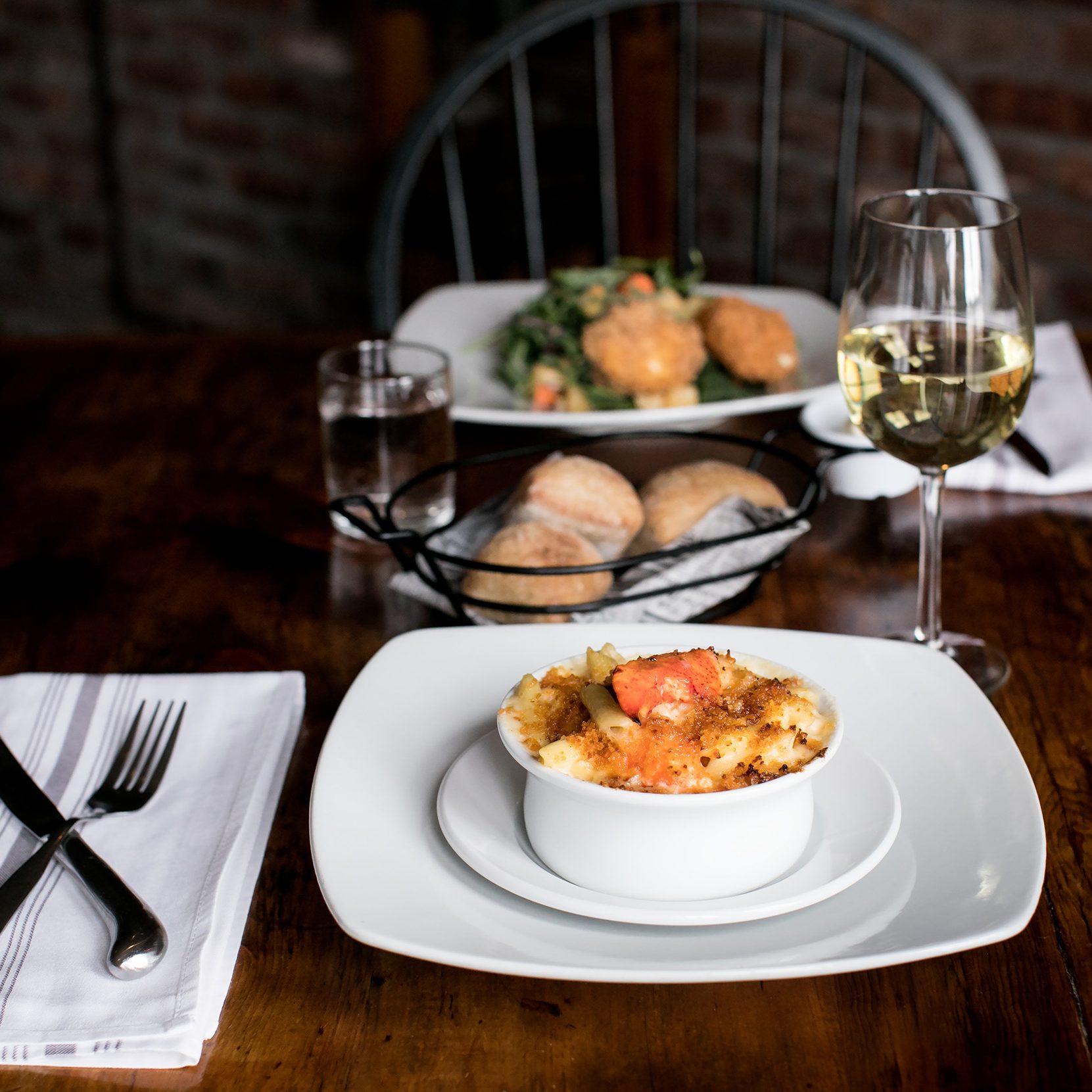 Plate of lobster macaroni and cheese and glass of white wine. The Century House, Latham, Albany County