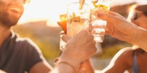 Group of people cheering their drinks outside