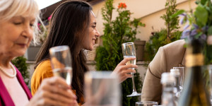 Group of people dining and cheering champagne flutes outside