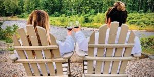 Two women in chairs cheering wineglasses at the Emerson Resort & Spa