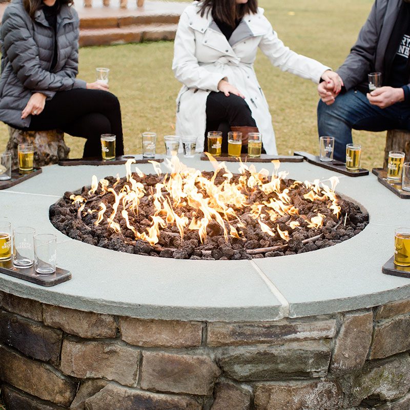 People gathered around an Angry Orchard campfire in Walden.